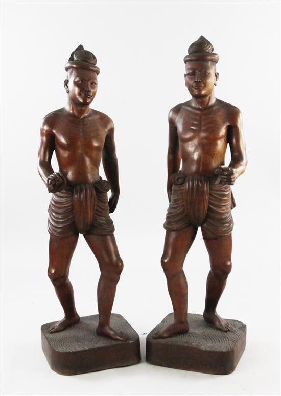 A pair of large Balinese teak figures of native men, first half 20th century, 123cm. and 126cm.